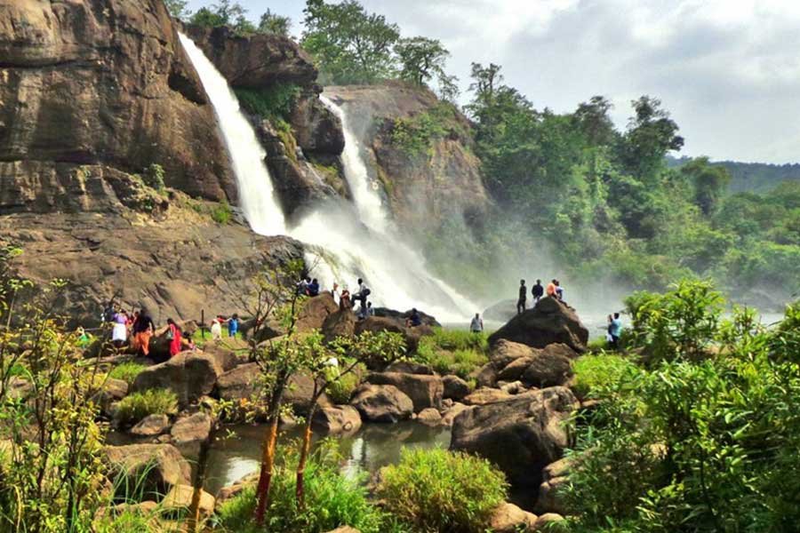 A scenic waterfall surrounded by greenery in Kerala, known for its natural beauty and lush landscapes