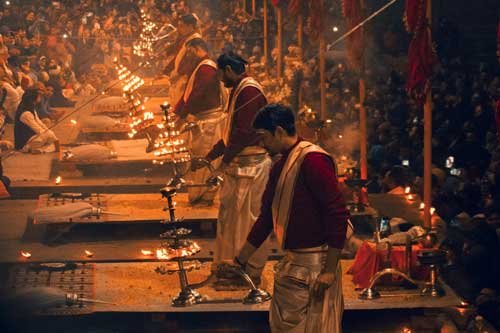 Priests performing the traditional Ganga Aarti ceremony on the ghats of Varanasi with glowing lamps and spiritual atmosphere