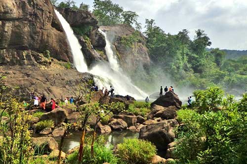 A scenic waterfall surrounded by greenery in Kerala, known for its natural beauty and lush landscapes